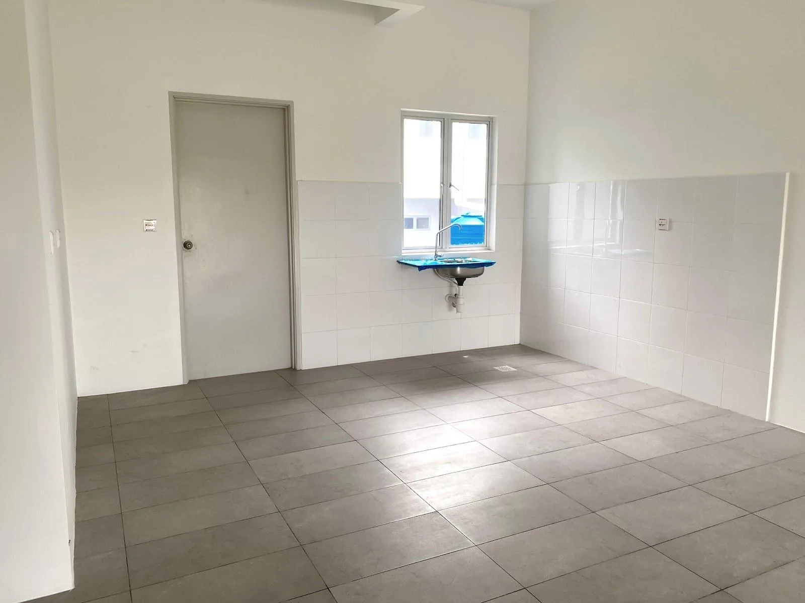 Type C3 kitchen as handed over, with wall tiles and a sink — photograph from the developer’s presentation at Bandar Sri Indah, Jalan Apas, Tawau, Sabah