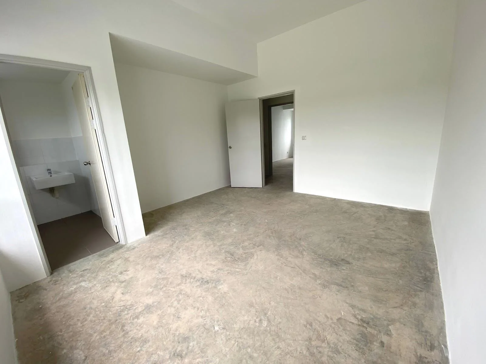 Type C3 master bedroom as handed over, with cement-screed floor and attached bathroom — photograph from the developer’s presentation at Bandar Sri Indah, Jalan Apas, Tawau, Sabah