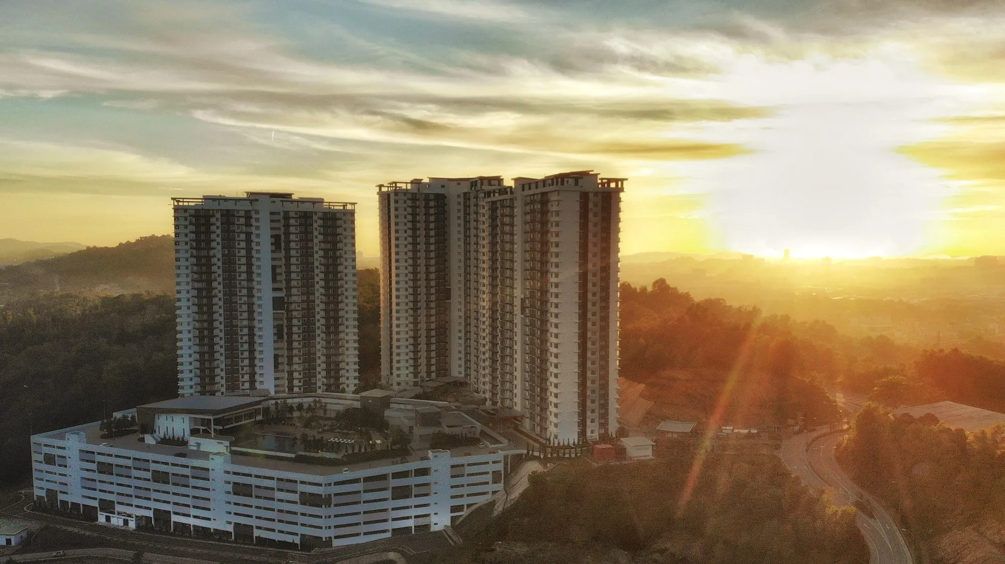 The three towers above the podium car park at sunset, from the developer’s brochure at Bukit Bantayan Residences, Inanam, Kota Kinabalu, Sabah