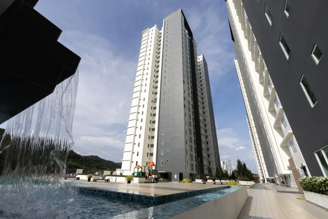 Emerald Residence pool deck with water feature and a tower block behind, Teluk Kumbar, Penang