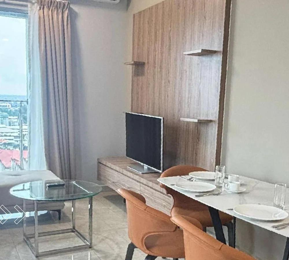 Living and dining area of a furnished 706 sq ft two-bedroom suite with city view at ICC Suites, Ipoh, Perak
