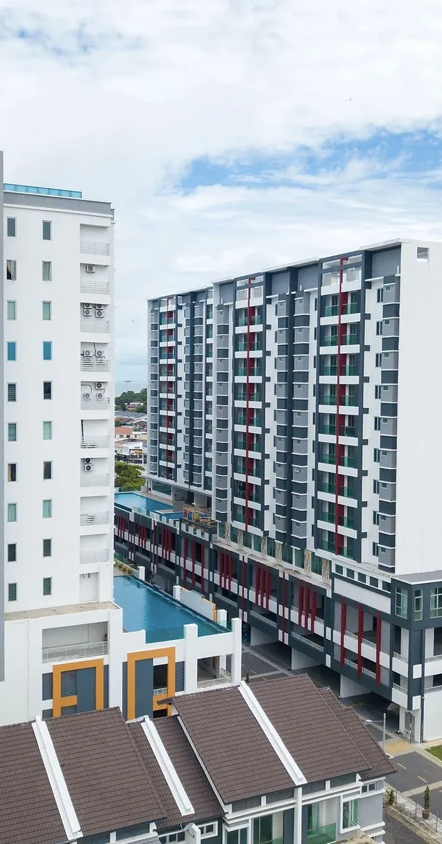 Drone photograph of the completed Marminton Homes block with red accents and the link-house roofs in front, Raja Uda, Butterworth, Penang