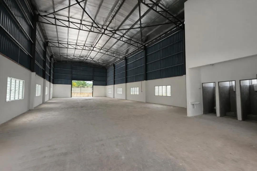 Warehouse interior of a completed unit at Valdor @ Taman IKS Nafiri, with a high steel-truss roof and washrooms at the side