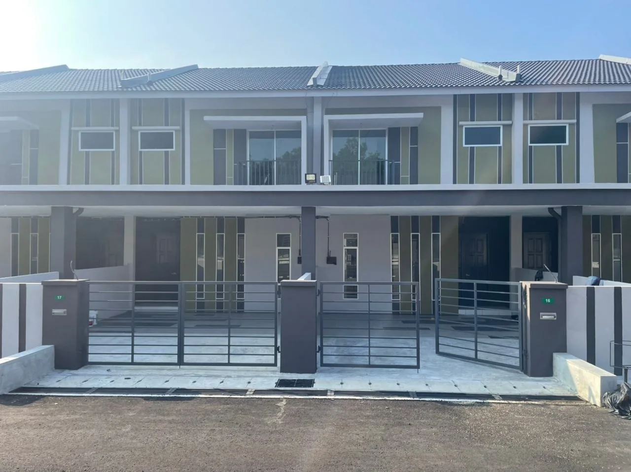Front of a completed double-storey terrace pair with gates at Taman Sejahtera, Kuala Kangsar, Perak