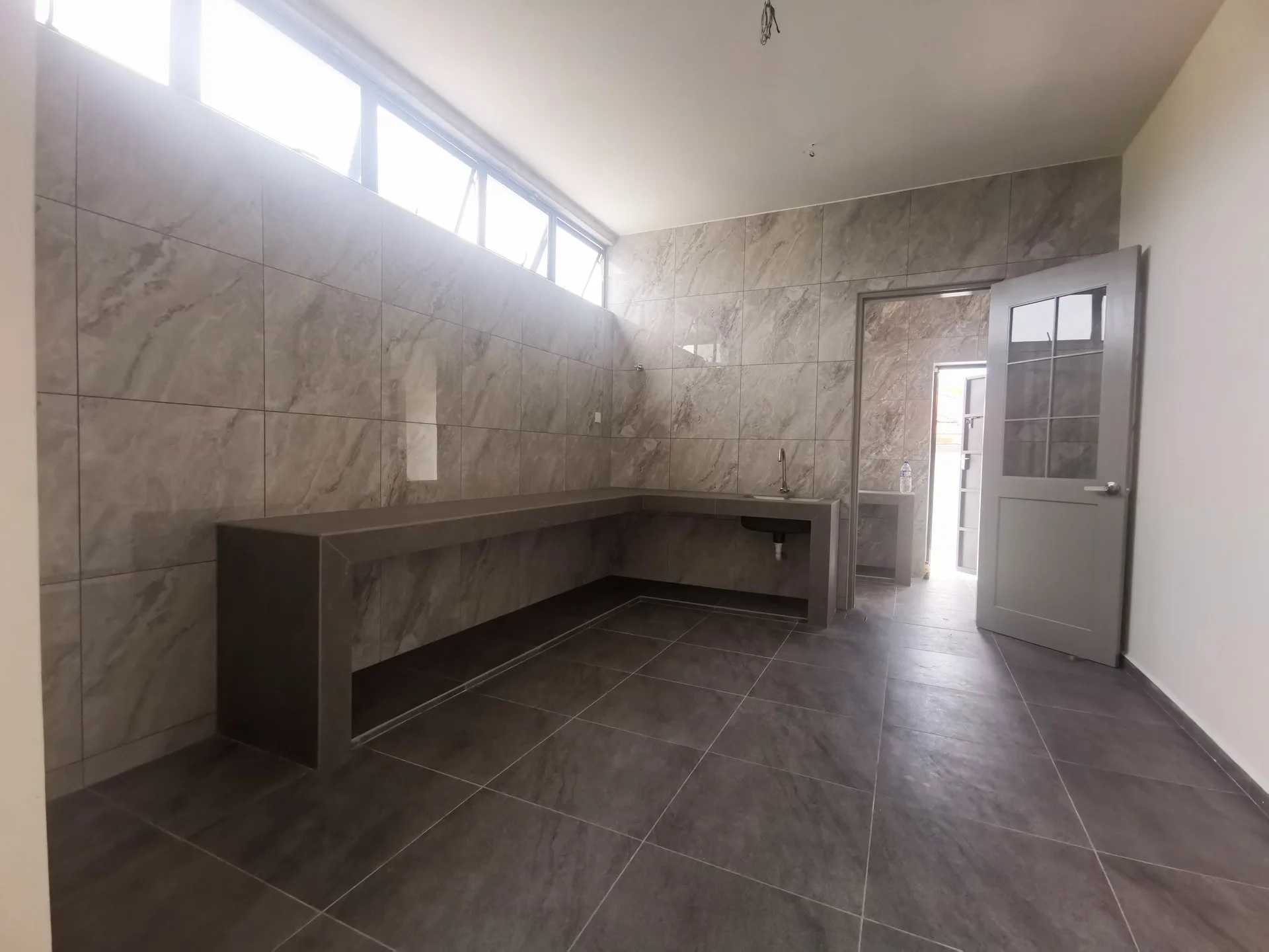 Kitchen with built-in concrete counter in a completed semi-detached unit at The Aster @ Taman Sinfar by Constant Builder Sdn Bhd, Jalan Pasir Puteh, Ipoh, Perak