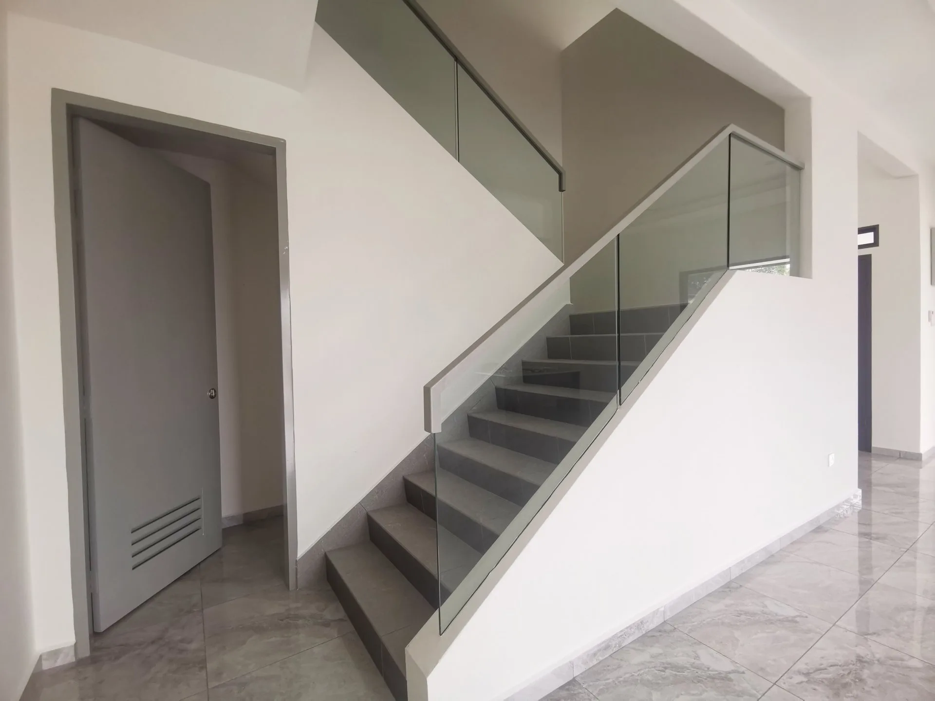 Staircase with glass balustrade in a completed semi-detached unit at The Aster @ Taman Sinfar by Constant Builder Sdn Bhd, Jalan Pasir Puteh, Ipoh, Perak